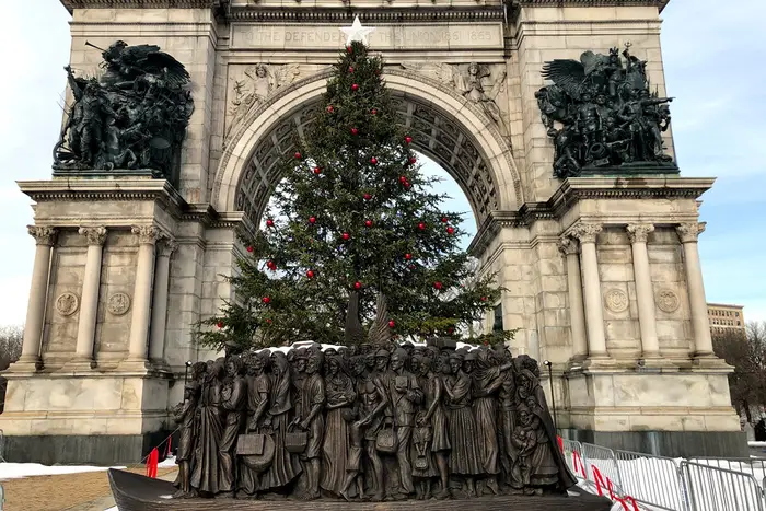 A photo of the Immigrant statue and Christmas tree at Grand Army Plaza